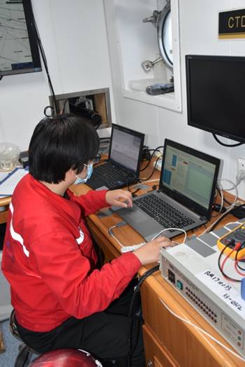 A group of people looking at a computerDescription automatically generated